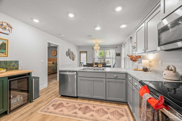 8820 Smiley Ct, Pensacola, FL 32514 - kitchen with stainless steel appliances, wine cooler, gray cabinets, a peninsula, and a textured ceiling