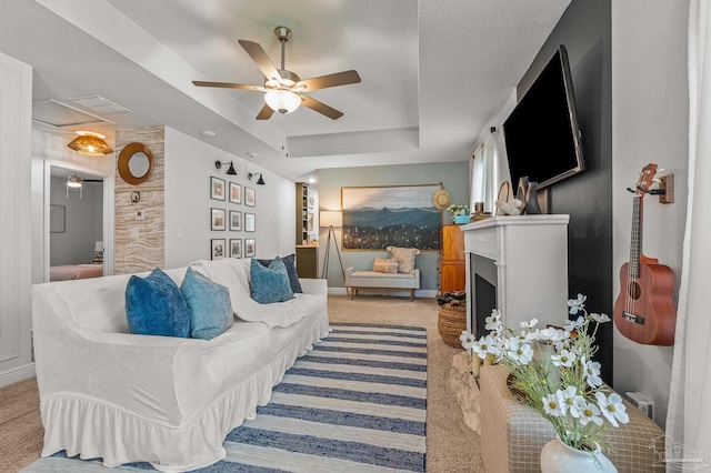 8820 Smiley Ct, Pensacola, FL 32514 - living area with light carpet, ceiling fan, a tray ceiling, and a fireplace