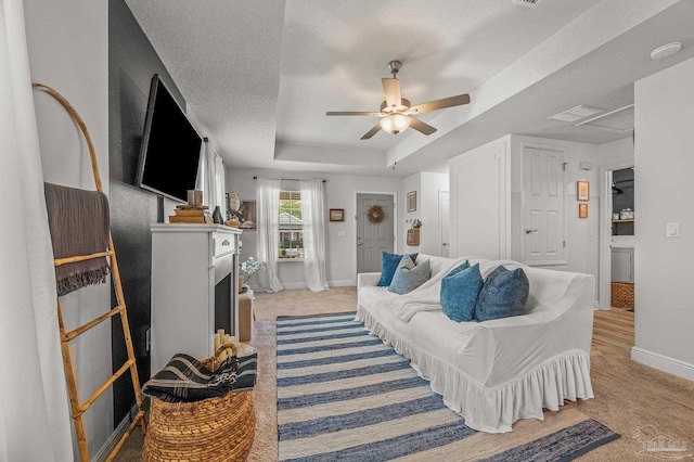 8820 Smiley Ct, Pensacola, FL 32514 - living area featuring light colored carpet, a raised ceiling, a ceiling fan, and a fireplace