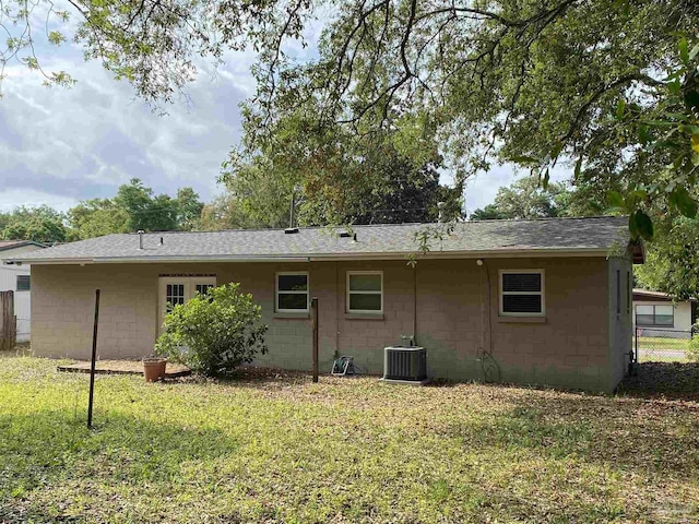 925 Artesian Ave, Pensacola, FL 32505 - rear view of house with roof with shingles, central air condition unit, fence, a yard, and concrete block siding