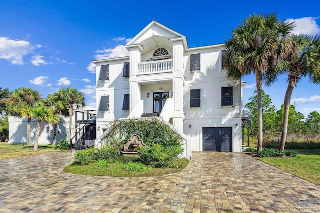 view of front of property featuring a balcony and a garage