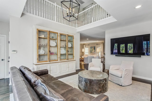 living room featuring a chandelier, a towering ceiling, and hardwood / wood-style flooring