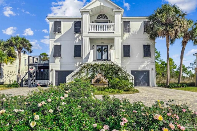 view of front of property featuring a balcony and a garage