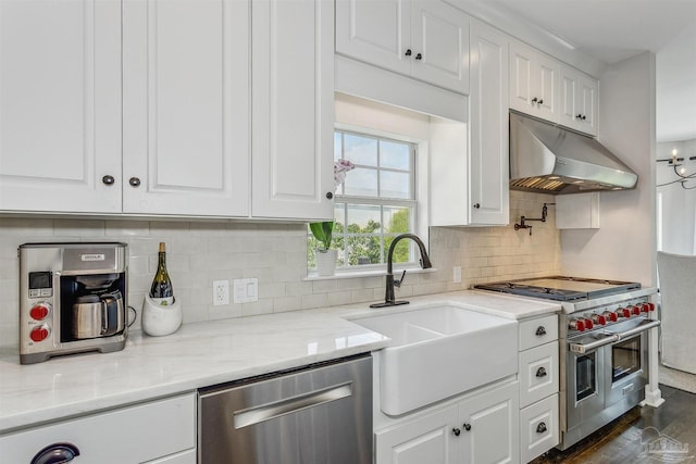 kitchen featuring tasteful backsplash, light stone countertops, white cabinets, and stainless steel appliances