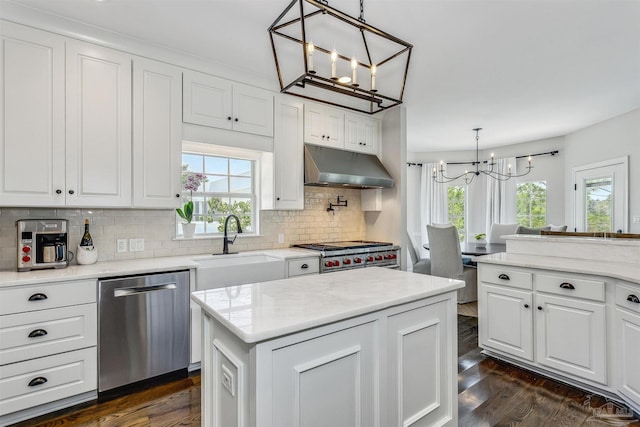 kitchen featuring white cabinets, decorative light fixtures, backsplash, and stainless steel appliances