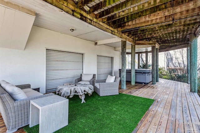 deck featuring a hot tub and a lawn