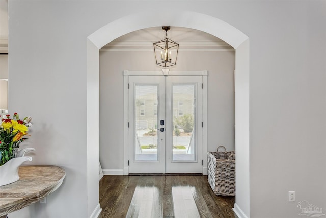 doorway to outside featuring an inviting chandelier, dark hardwood / wood-style flooring, ornamental molding, and french doors