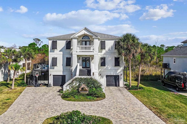 view of front of home featuring a balcony, central AC unit, a front yard, and a garage