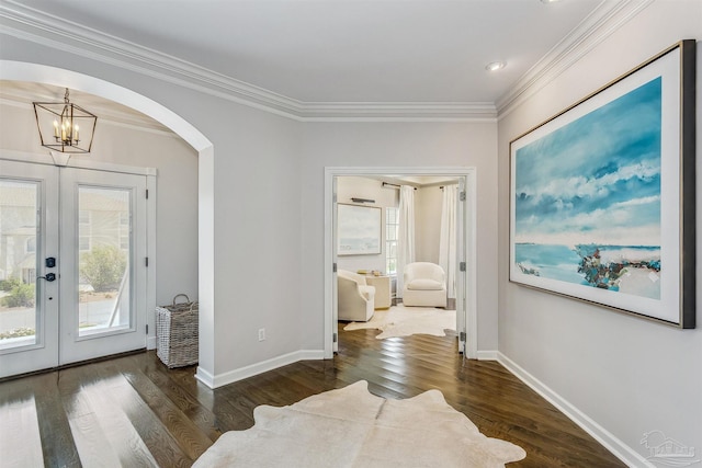 interior space featuring an inviting chandelier, dark hardwood / wood-style flooring, ornamental molding, and french doors