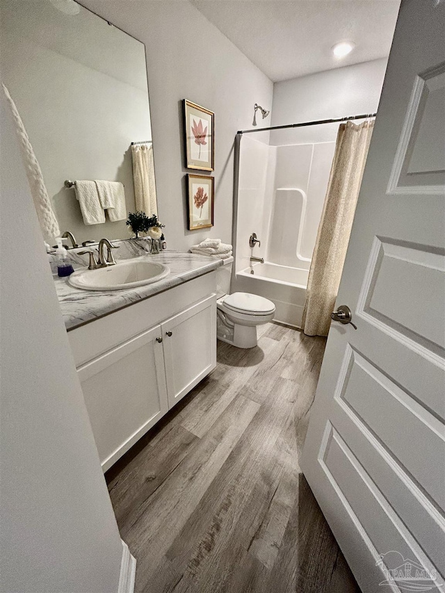 bathroom with shower / bath combination with curtain, vanity, toilet, and wood finished floors