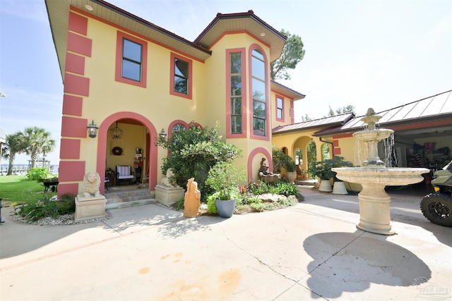 view of front of property with metal roof, a standing seam roof, and stucco siding