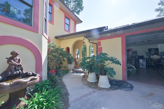 entrance to property featuring a garage and stucco siding