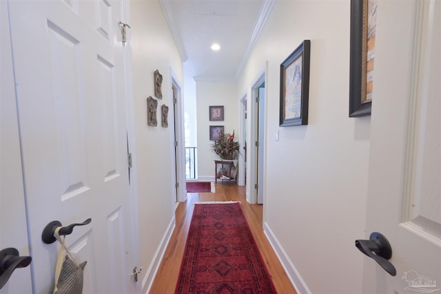 hall featuring recessed lighting, baseboards, crown molding, and wood finished floors