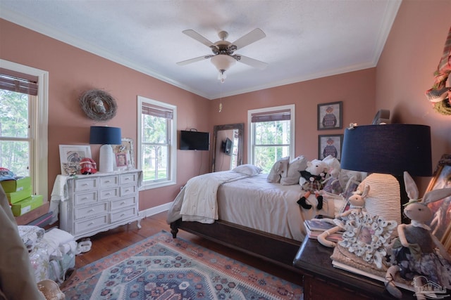 bedroom featuring light wood-type flooring, multiple windows, crown molding, and baseboards