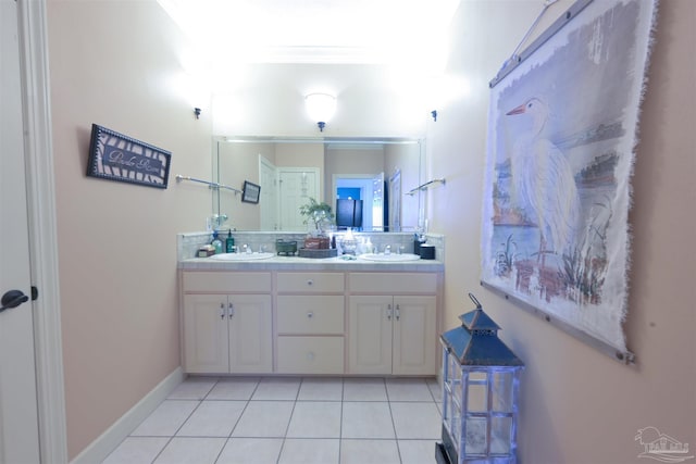 full bathroom with double vanity, tile patterned flooring, a sink, and baseboards