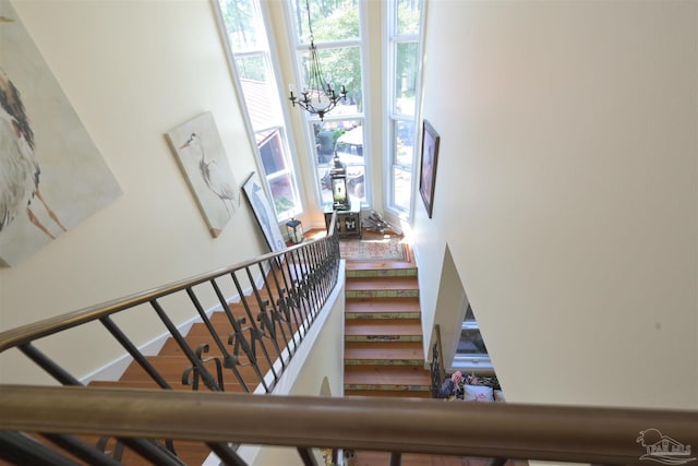 stairs with a notable chandelier