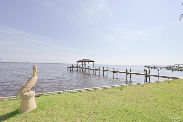 dock area with a water view and a lawn