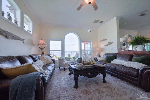 living area with ceiling fan, ornamental molding, and visible vents