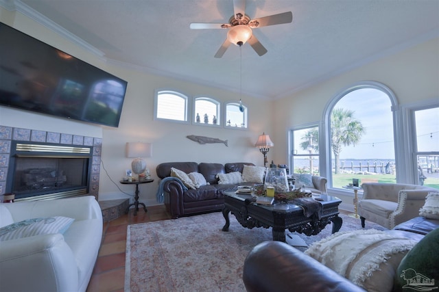 living room with a brick fireplace, crown molding, and ceiling fan