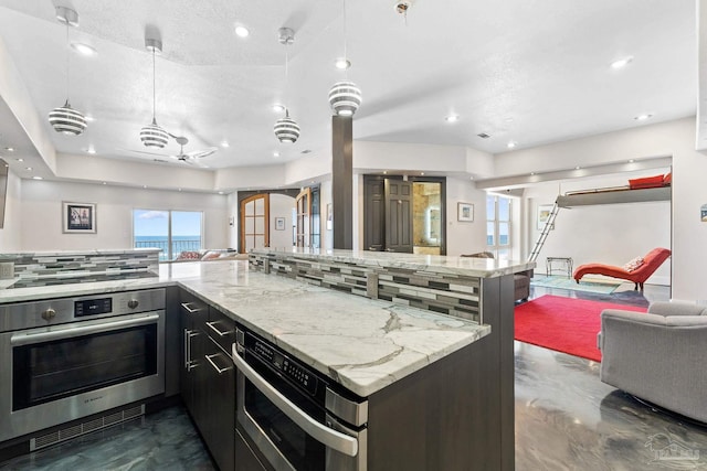 999 Ft Pickens Rd Unit 309, Pensacola Beach, FL 32561 - kitchen featuring pendant lighting, tasteful backsplash, black electric stovetop, stainless steel oven, and light stone counters
