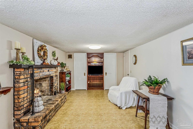 living room with a textured ceiling and a brick fireplace