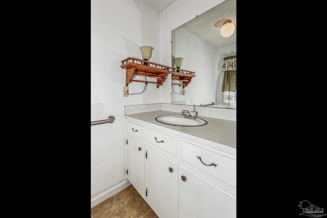 bathroom with tile patterned floors, vanity, and a textured ceiling