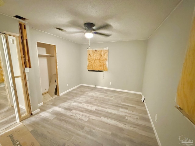 unfurnished bedroom featuring a textured ceiling, light hardwood / wood-style floors, and ceiling fan