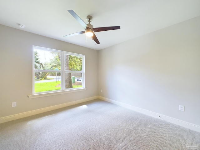 empty room with carpet floors, baseboards, and a ceiling fan