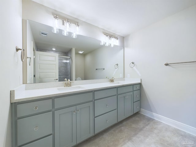 bathroom featuring a stall shower, a sink, visible vents, and baseboards