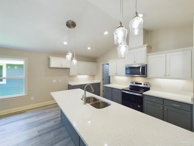 kitchen with gray cabinetry, a sink, white cabinetry, hanging light fixtures, and appliances with stainless steel finishes