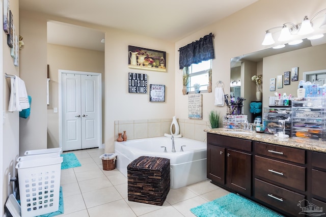 bathroom featuring tile patterned floors, a bath, and vanity