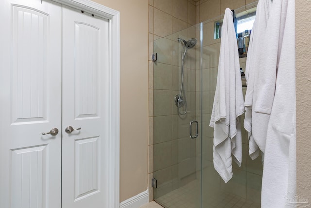 bathroom with a stall shower and baseboards