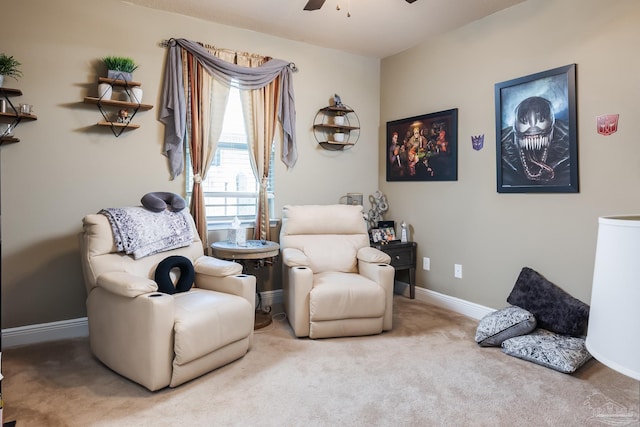 sitting room with a ceiling fan, carpet, and baseboards