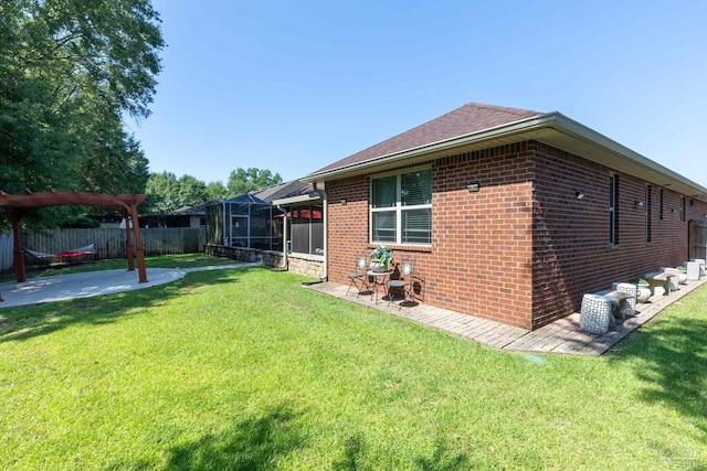 view of side of property featuring glass enclosure, brick siding, a patio, and a lawn