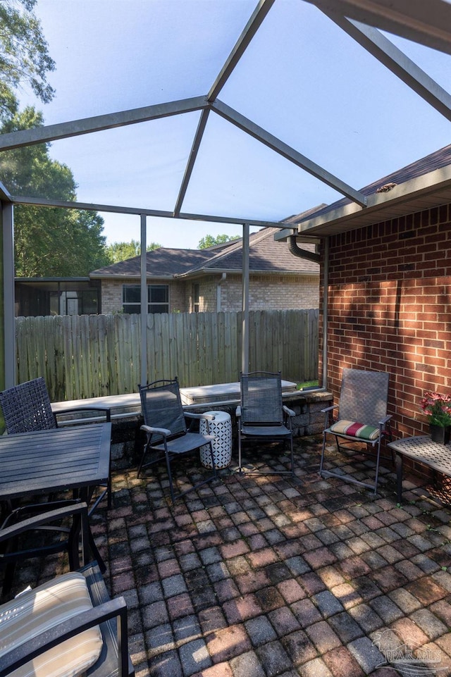 view of patio / terrace featuring glass enclosure and fence