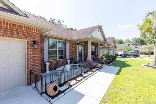 property entrance featuring a porch, brick siding, a yard, and a garage