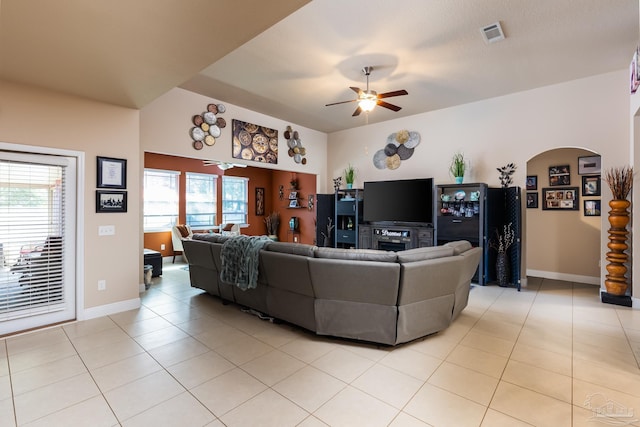 living area featuring arched walkways, visible vents, ceiling fan, and light tile patterned floors