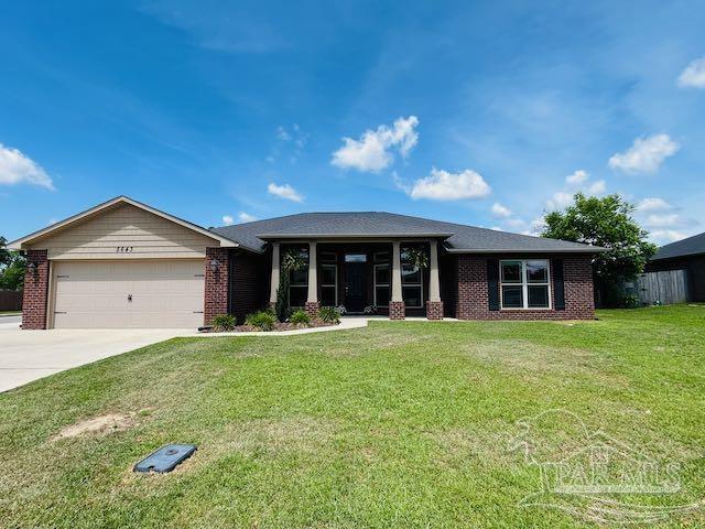 5643 Flume Dr, Pace, FL 32571 - view of front of home with an attached garage, brick siding, driveway, and a front lawn