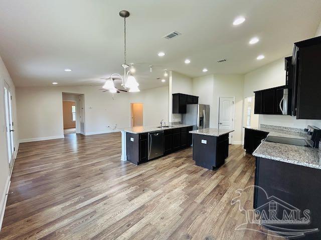 5643 Flume Dr, Pace, FL 32571 - kitchen featuring dark cabinetry, a sink, appliances with stainless steel finishes, open floor plan, and recessed lighting