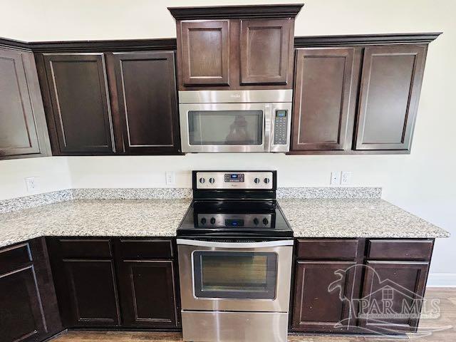 5643 Flume Dr, Pace, FL 32571 - kitchen featuring stainless steel appliances, dark brown cabinets, light wood-type flooring, and light stone counters