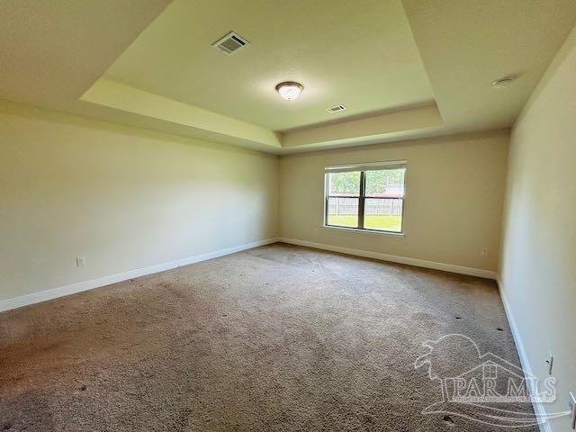 5643 Flume Dr, Pace, FL 32571 - carpeted empty room featuring a raised ceiling and baseboards
