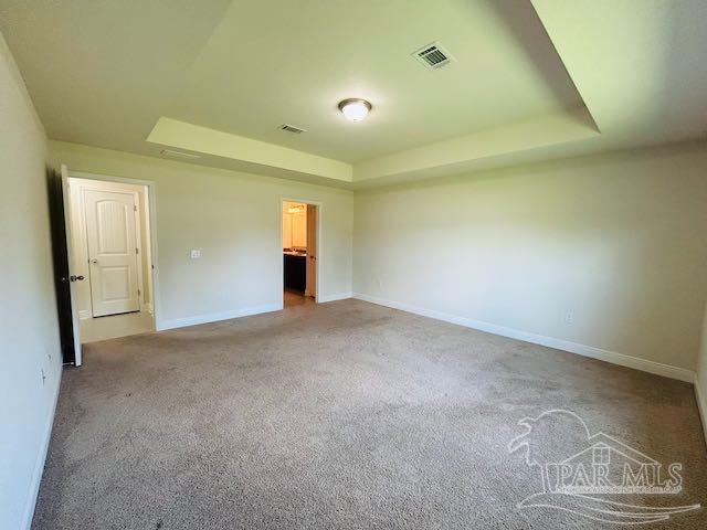 5643 Flume Dr, Pace, FL 32571 - unfurnished bedroom featuring a tray ceiling, carpet, and baseboards