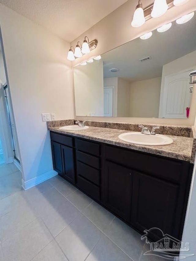 5643 Flume Dr, Pace, FL 32571 - bathroom with double vanity, tile patterned flooring, baseboards, and a stall shower