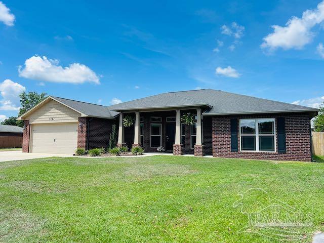 5643 Flume Dr, Pace, FL 32571 - view of front of house with brick siding, driveway, and a garage