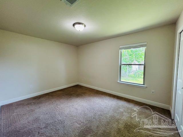 5643 Flume Dr, Pace, FL 32571 - spare room featuring baseboards and dark colored carpet