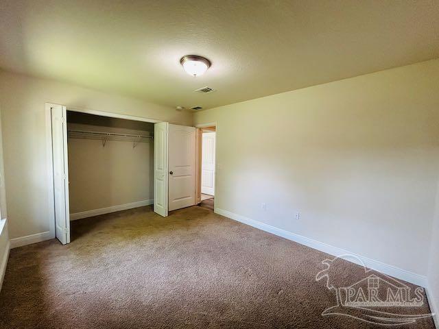 5643 Flume Dr, Pace, FL 32571 - unfurnished bedroom featuring baseboards, carpet, and a closet