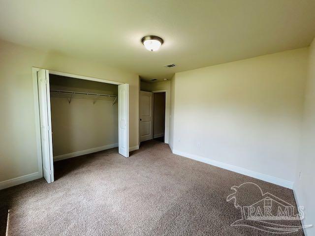 5643 Flume Dr, Pace, FL 32571 - unfurnished bedroom with carpet floors, baseboards, and a closet