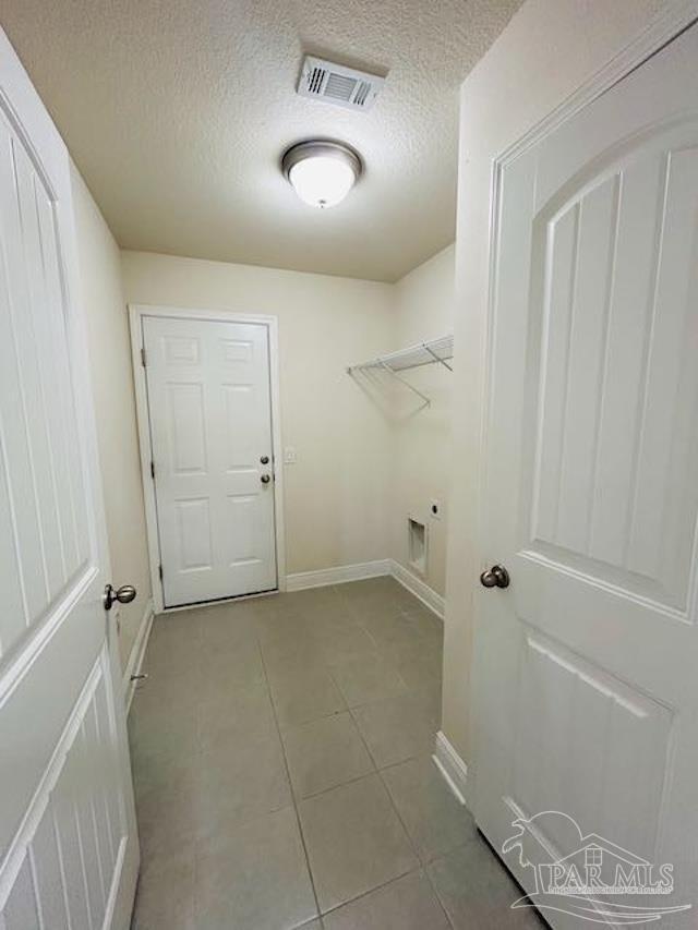 5643 Flume Dr, Pace, FL 32571 - laundry area with hookup for an electric dryer, a textured ceiling, baseboards, and tile patterned floors