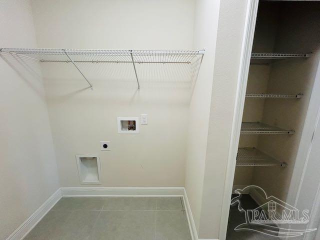 5643 Flume Dr, Pace, FL 32571 - laundry room featuring hookup for a washing machine, hookup for an electric dryer, baseboards, and tile patterned flooring