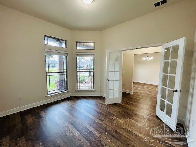 5643 Flume Dr, Pace, FL 32571 - spare room with french doors, dark wood-style floors, a chandelier, and baseboards